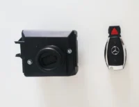 A car key and remote control on the wall.
